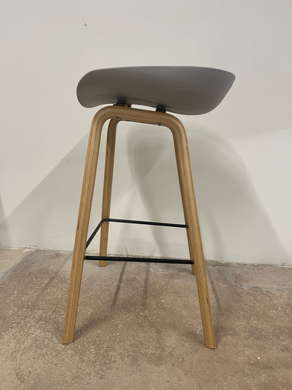 Front view of Scandinavian counter stool with wooden legs and black footrest