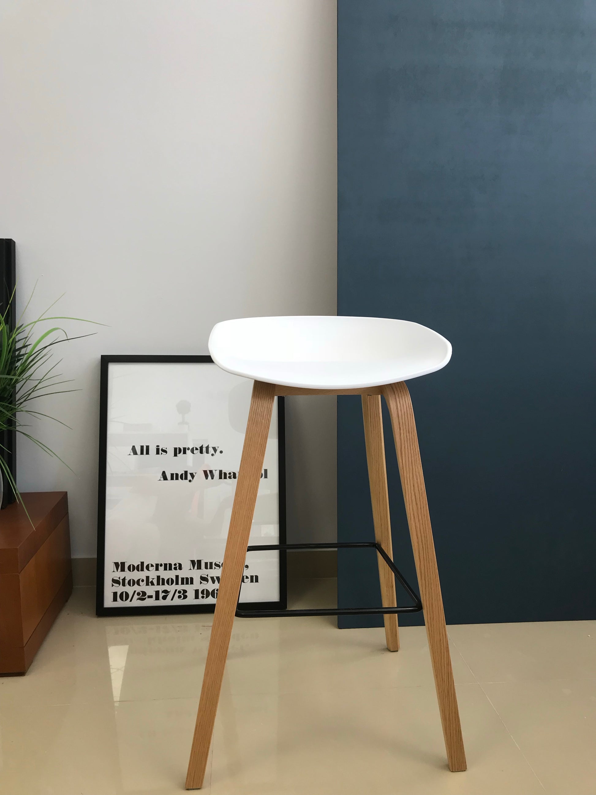 Modern Scandinavian counter stool with grey seat in contemporary interior