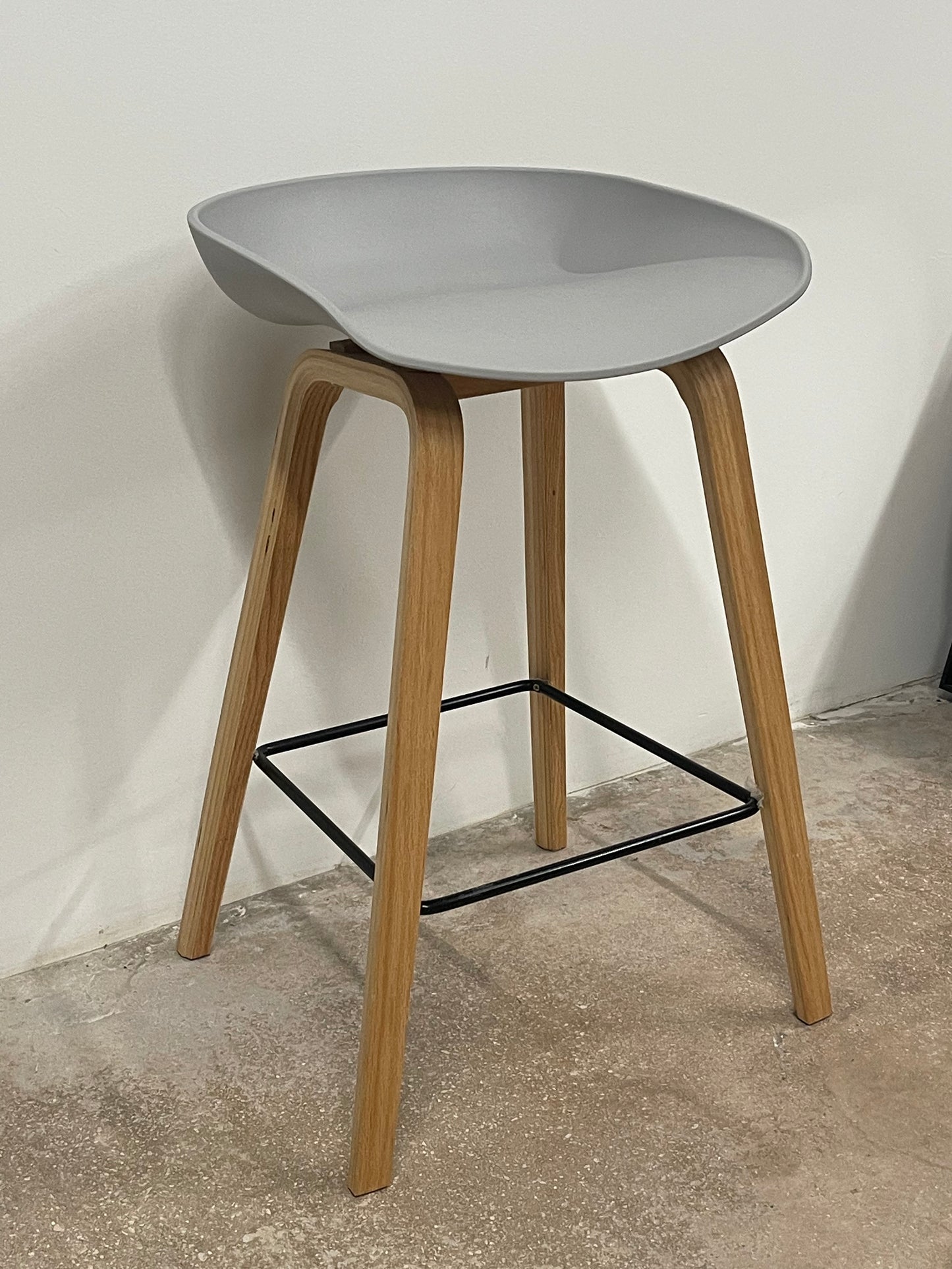 Modern Scandinavian counter stool with grey seat and wooden legs