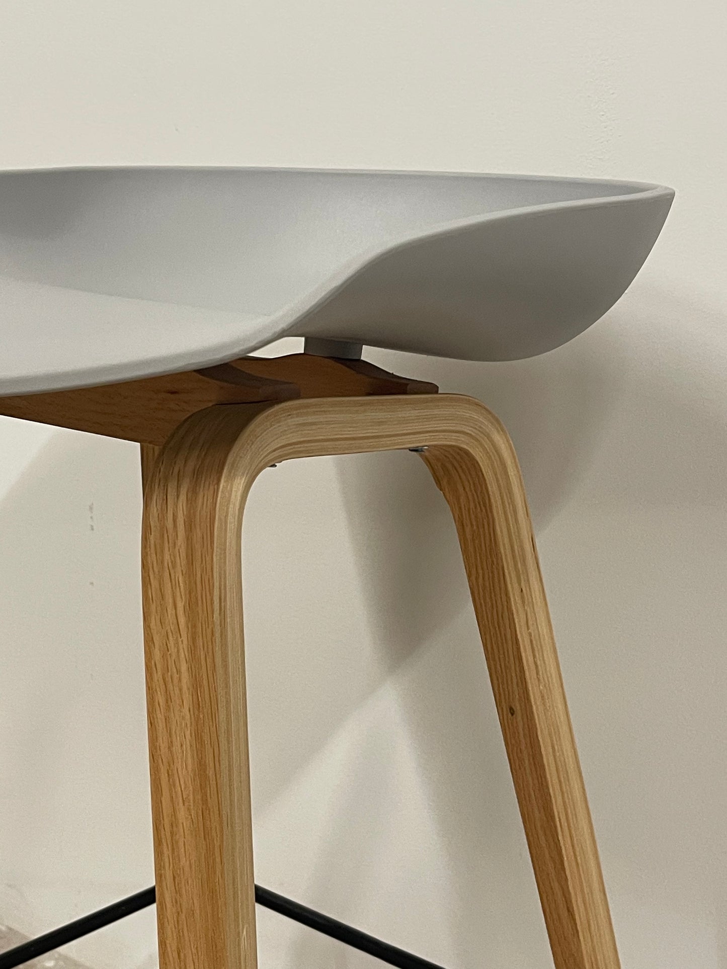 Close-up of grey Nordic counter stool seat and wooden frame