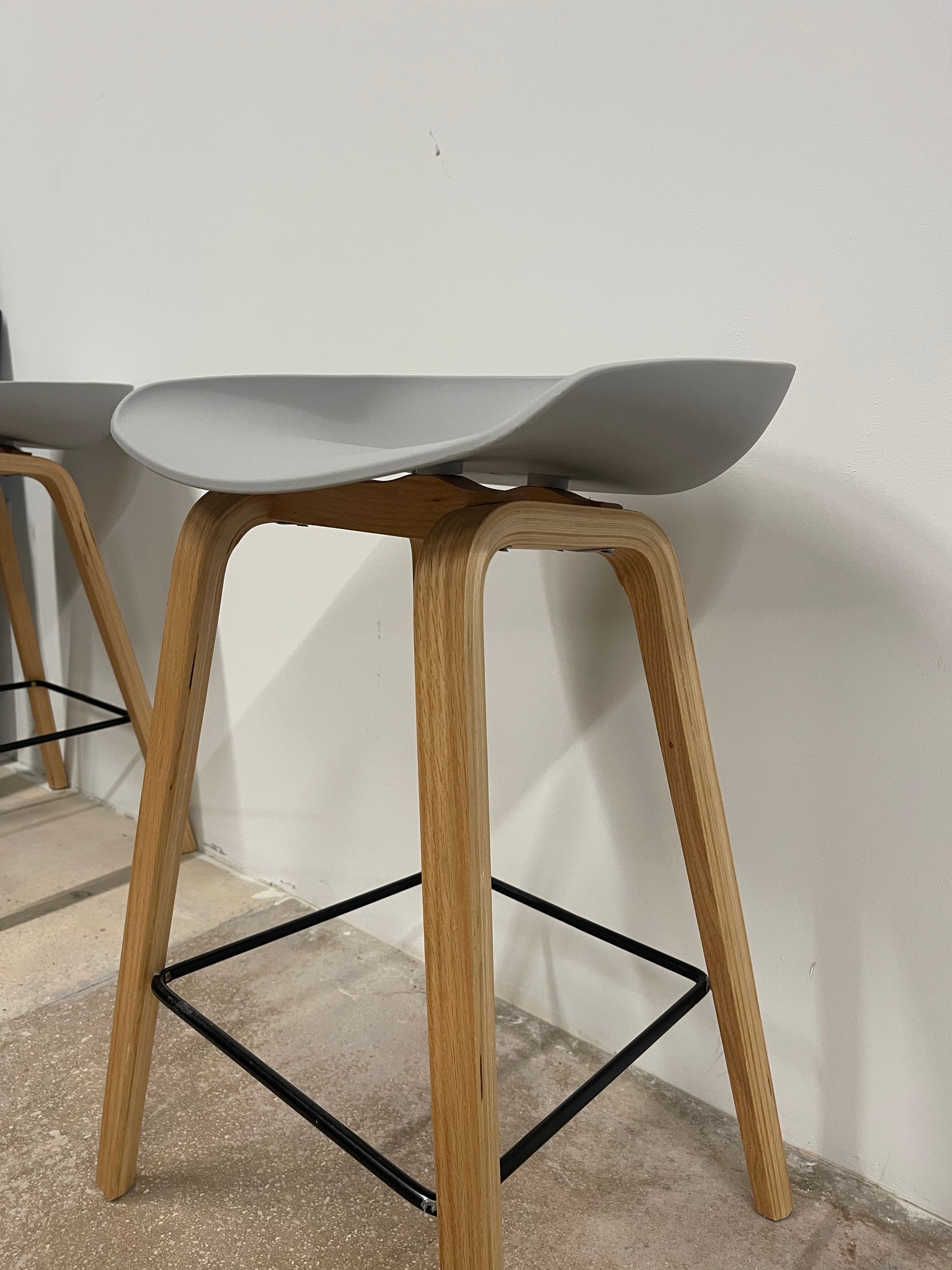 Pair of Nordic counter stools with grey seats and natural wood legs