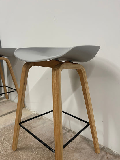 Pair of Nordic counter stools with grey seats and natural wood legs