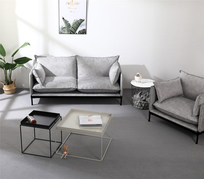 Modern office waiting room seating arrangement featuring grey 2-seater sofa and single guest chair with coffee tables